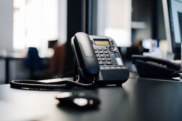 Phone on a black desk.by Julian Hochgesang